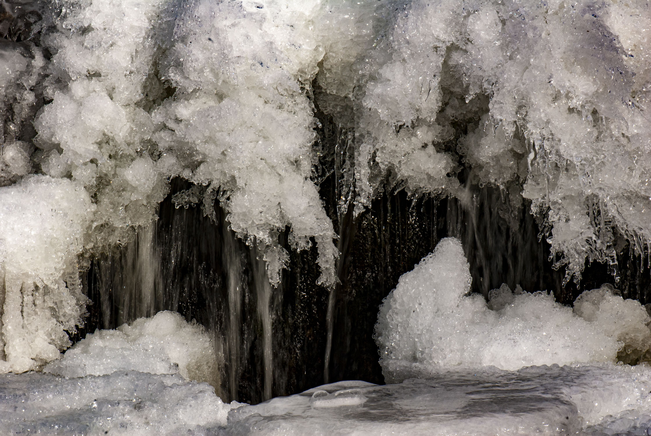 Frozen water and snow with some running water behind it